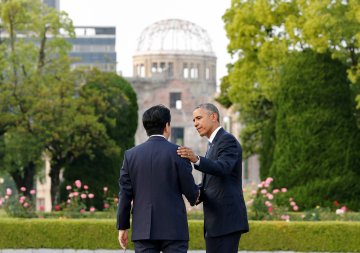 U.S. President Barack Obama puts arm around Japanese PM Abe after they laid wreaths in front of cenotaph as the atomic bomb dome is background at Hiroshima Peace Memorial Park in Hiroshima, Japan